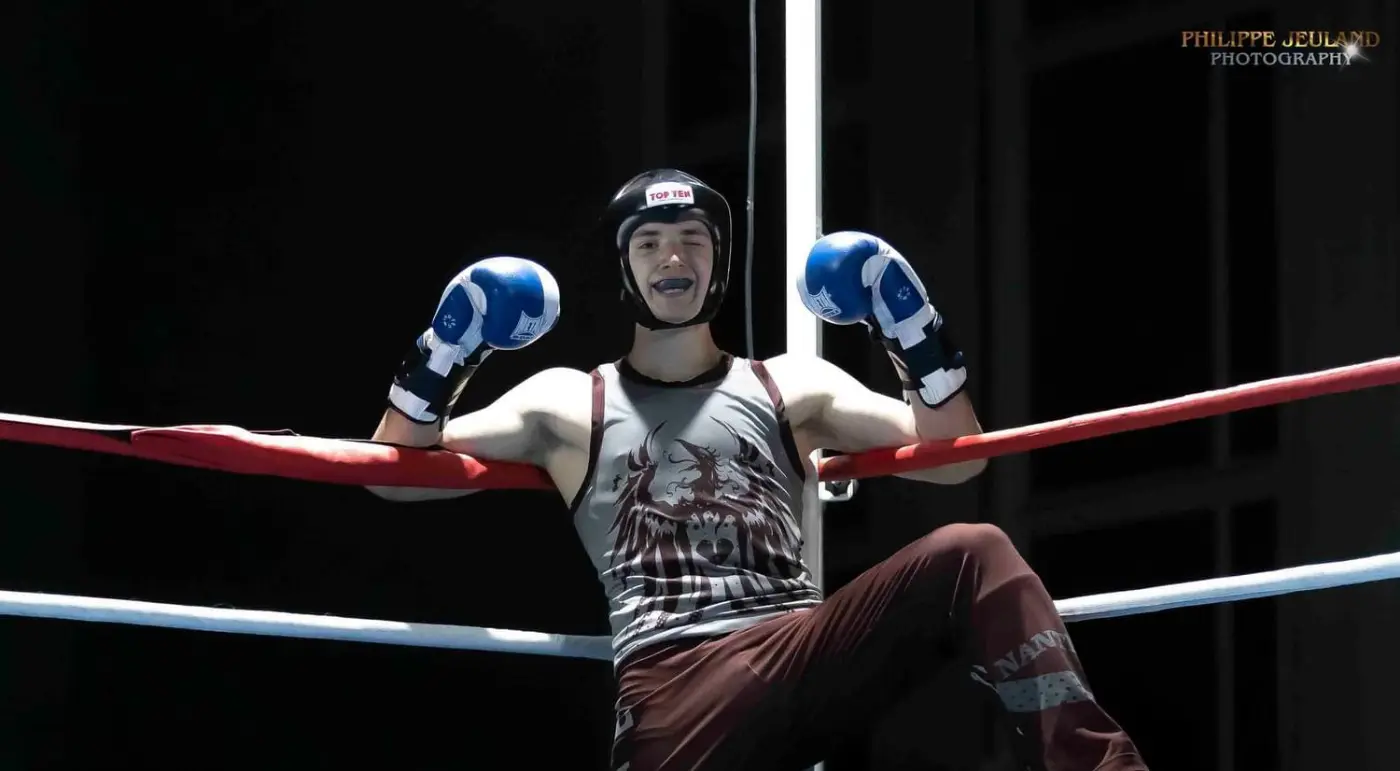Yann Laurent assis dans les cordes du ring, casque et gants de boxe, entre deux reprises.